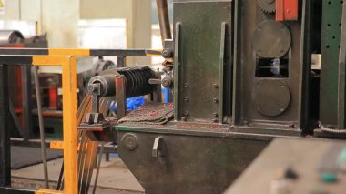 Çelik fabrikası atölyesinde mekanik ekipmanlar çalışıyor.