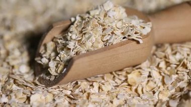  Pişmemiş yulaf yığını dönüyor. Yulaf ezmesi. Yulaf gevreği. Kuru yulaf taneleri arka planda. Yiyecek.