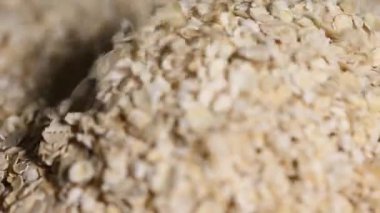  Pişmemiş yulaf yığını dönüyor. Yulaf ezmesi. Yulaf gevreği. Kuru yulaf taneleri arka planda. Yiyecek.