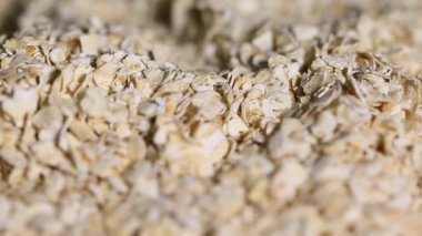  Pişmemiş yulaf yığını dönüyor. Yulaf ezmesi. Yulaf gevreği. Kuru yulaf taneleri arka planda. Yiyecek.