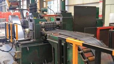 Çelik fabrikası atölyesinde mekanik ekipmanlar çalışıyor.