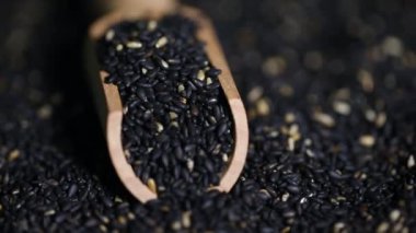 Dönen siyah susam tohumları, susam yağı, yakın çekim.