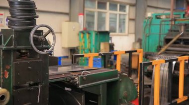 Çelik fabrikası atölyesinde mekanik ekipmanlar çalışıyor.