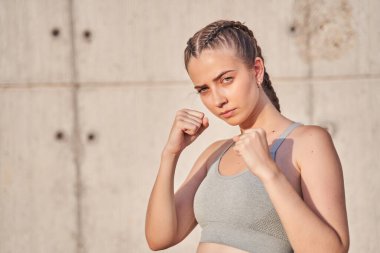 Güzel ve formda bir kadın dövüşçünün dövüşe ya da eğitime hazırlanırken çekilmiş bir portresi.