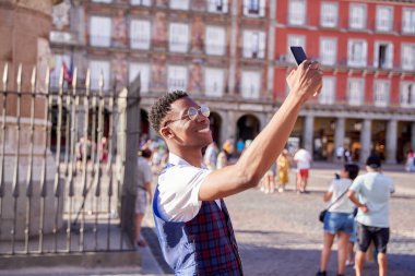 Madrid belediye başkanını ziyaret eden genç bir turist akıllı telefonuyla selfie çekiyor..