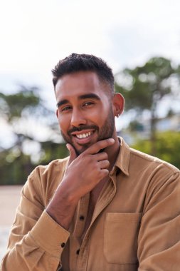 Elleri çenesinde poz veren yakışıklı bir Latin 'in portresi.