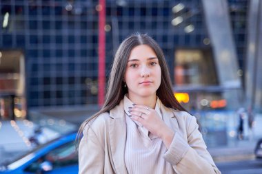 Ceketli genç bir kadının portresi kameraya bakıyor.