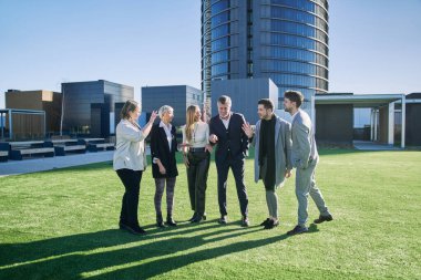 Takım çalışması dışarıda konuşuluyor. Erkek ve kadın birlikte iş şirketinde başarıyı kutluyorlar..