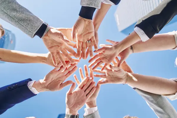 group of business people joining hands, low angle view. concept of business, teamwork, union of workers and agreements.