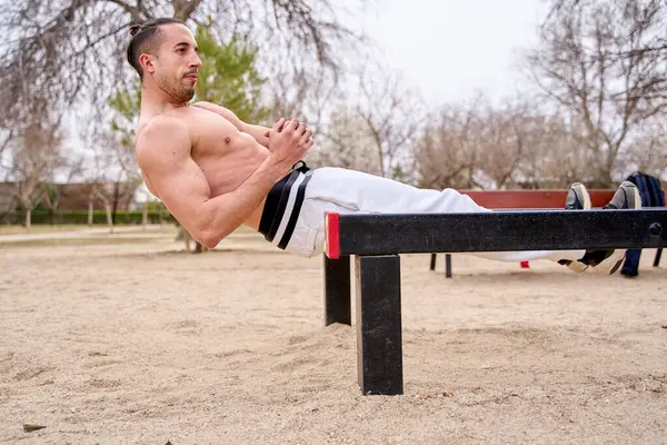 Man doing crunches in street workout park