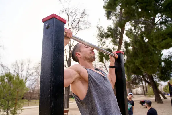 Strong man athlete doing chin-ups during calisthenics workout