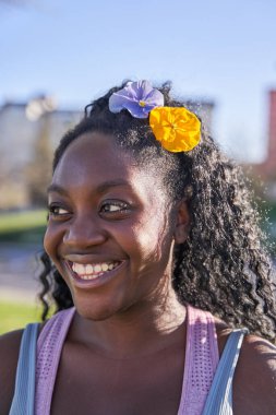 Saçında çiçekler olan Afro-Amerikan kadın portresi.