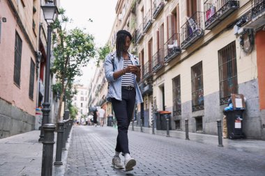 Akıllı telefonlu gülümseyen adam. Sıradan giyinmiş siyah bir adam. yaşam tarzı konsepti.