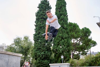 Ekstrem patenler üzerinde patenci bulutlu gökyüzünde akrobatik atlayış yapıyor - alternatif yaşam tarzı konsepti