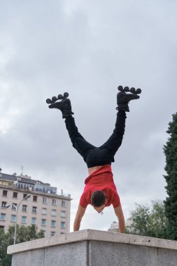 Genç sporcu şehirde pino dansı yapıyor, paten kayıyor.