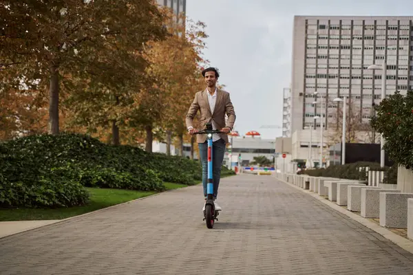 Genç işadamı ofise giderken elektrikli scooter kullanıyor.