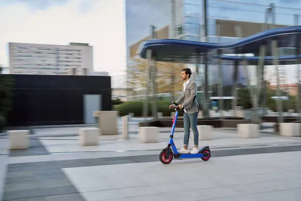 Genç bir işadamının elektrikli scooterını kullanarak etrafı kirletmeden dolaşırken ki görüntüsü..