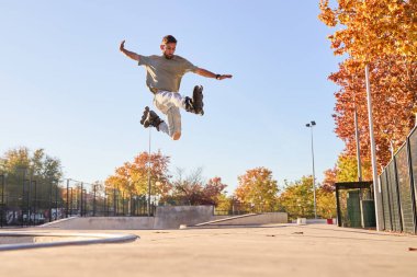 young male roller skater jumping and doing a trick with his inline skates. clipart