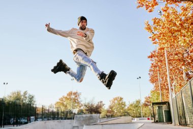 young male roller skater jumping and doing a trick with his inline skates. clipart