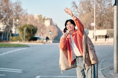 Sokakta dururken taksi çağırmak için cep telefonu kullanan çekici bir adam..