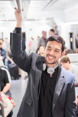 Metro vagonunda duran iş adamı. Bir gün çalıştıktan sonra trenle eve dönen bir adam..
