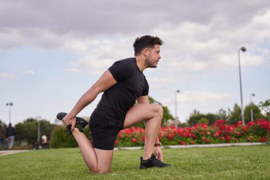 Açık hava parkında egzersiz yapmadan önce esneme hareketleri. Genç Latin spor yapmaya hazırlanıyor..