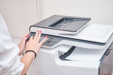 Tanımlanamayan iş kadını yazıcı kullanıyor. İş kadını yeni bir şirket projesi için belge basıyor.