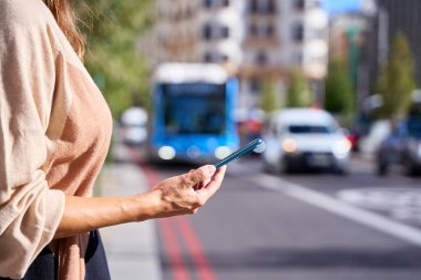 Cep telefonu taksiyi arayan bir kadının elinin yakın plan görüntüsü.