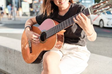 Sokakta gitar çalan bir kadının detayları..