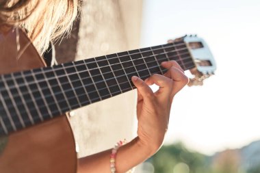Arka planı bulanık bir gitarın perdelerinde bir kadının elini kapat.