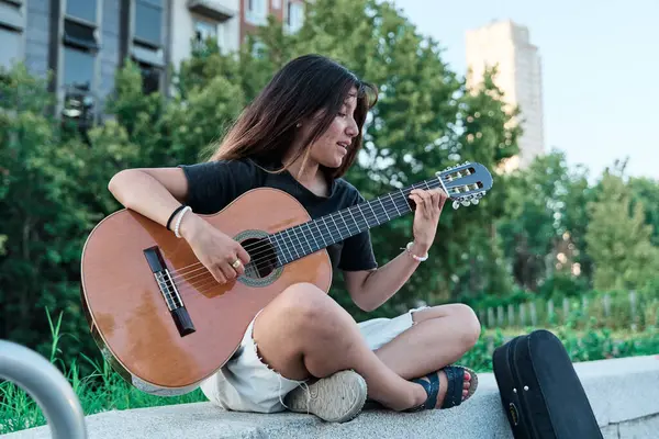 Genç bir Latin şehirde gitar çalıyor. Bir bankta oturan kadın müzik aleti ile pratik yapıyor..