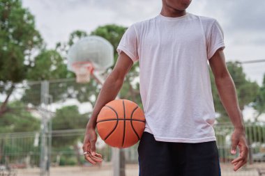 Sahada elinde basketbol topuyla tanınmayan bir adam.