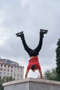 Genç sporcu şehirde pino dansı yapıyor, paten kayıyor.