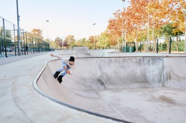 Genç yetenekli bir adam paten kayıyor ve dışarıdaki kaykay parkında rampada zıplıyor. Numaralarını ya da paten yarışması tekniğini deniyor.