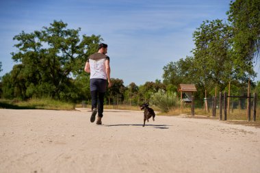 Adam kırsalda geziniyor, koşuyor ve oynuyor.