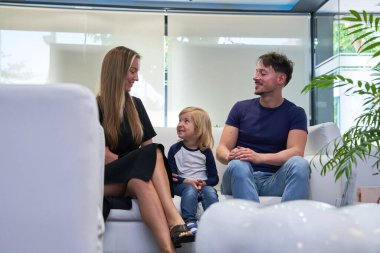 Anne ve anne birbirlerine bakarlar. Oğulları asık suratlı görünürken. Dişçinin bekleme odasında beklerler..