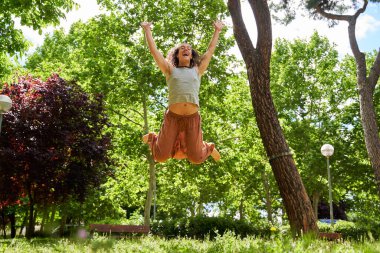 Uzun saçlı bir adam doğanın ortasında çağdaş dans ediyor.