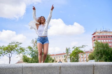 Latin bir kadın parkta dans ederken doğal ve açık havada dans etme isteğini ve zarafetini sergiliyor..