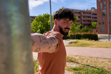 Genç bir atlet omuz ve kol ısınma egzersizleri yapıyor, yoğun bir antrenmana hazırlanıyor, sporda uygun ısınmanın önemini gösteriyor.