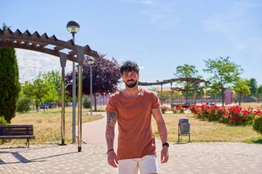 Açık hava parkında sakallı beyaz bir adamın portresi, sakin ve doğal ortamda rahat tavırlarını ve doğayla olan bağlantısını yakalıyor..