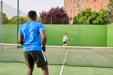 Sahada raket oynayan iki genç arkadaş. Spor konsepti. Boşluğu kopyala