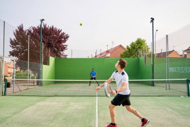 Sahada raket oynayan iki genç arkadaş. Spor konsepti. Boşluğu kopyala