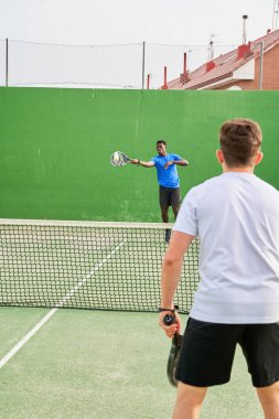 Sahada raket oynayan iki genç arkadaş. Spor konsepti. Boşluğu kopyala