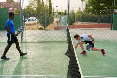 Sahada raket oynayan iki genç arkadaş. Spor konsepti. Boşluğu kopyala