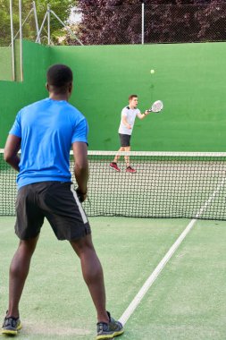 Sahada raket oynayan iki genç arkadaş. Spor konsepti. Boşluğu kopyala