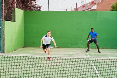 Sahada raket oynayan iki genç arkadaş. Spor konsepti. Boşluğu kopyala