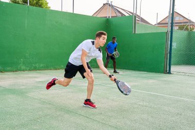 Sahada raket oynayan iki genç arkadaş. Spor konsepti. Boşluğu kopyala