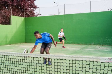 Sahada raket oynayan iki genç arkadaş. Spor konsepti. Boşluğu kopyala
