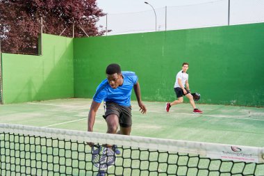 Sahada raket oynayan iki genç arkadaş. Spor konsepti. Boşluğu kopyala