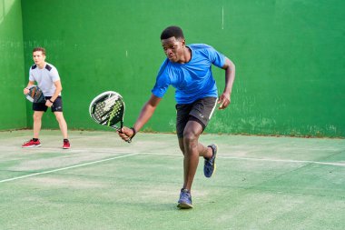 Sahada raket oynayan iki genç arkadaş. Spor konsepti. Boşluğu kopyala